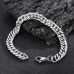 Detailed view of silver stainless steel curb chain bracelet with lobster clasp on rock