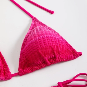 Dettaglio del top bikini rosso rosa con trama a spina di pesce e coppa a triangolo
