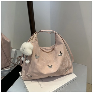 Pink nylon pleated shoulder bag featuring metal butterfly detail and a white cloud charm