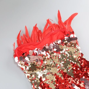 Close-up of red sequin embroidery and delicate feather trim on a fitted evening gown