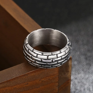 Macro detail of men's vintage punk steel ring with embossed brick wall pattern texture