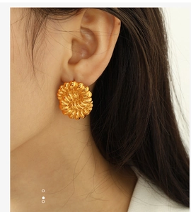 Detailed shot of vintage gold twisted floral earrings on a model showing elegant texture