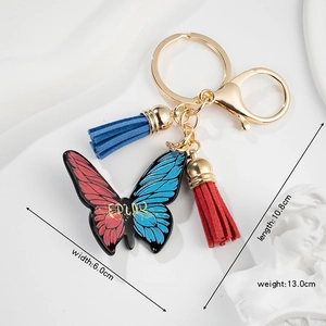 Red and blue gradient butterfly keychain with tassels and dimensions on white fabric