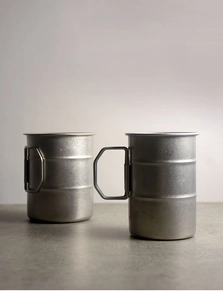 Macro view of portable stainless steel camping cups with folding handles and matte finish