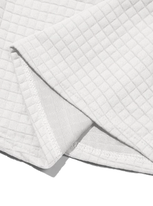 Detailed close-up of white waffle knit fabric texture and hem stitching on men pullover