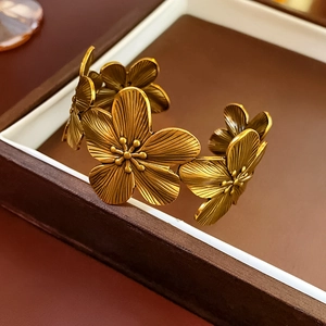 Detail of vintage flower cuff bracelet in antique gold finish on a jewelry box