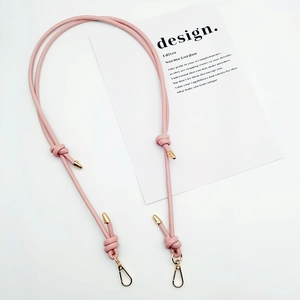 Detail of adjustable pink PU leather strap with gold lobster clasps and knotted design