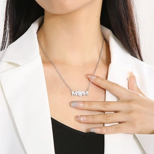 Close-up of MOM heart necklace in silver stainless steel on model neckline