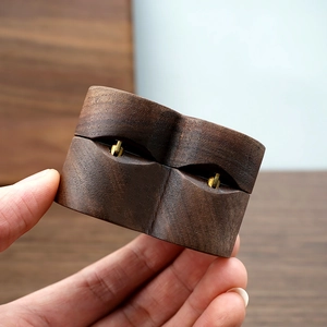 Close-up of handmade walnut wood heart ring box with metal hinge and natural grain