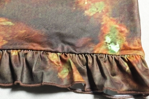 Détail de l'imprimé nébuleuse et des volants sur l'ourlet d'une robe moulante
