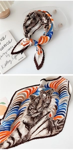 Detail of pleated silk scarf with tiger print in brown, orange and blue tones