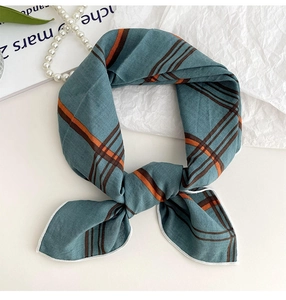 Close-up of gray-blue plaid cotton linen scarf with fine orange and brown stripe detail