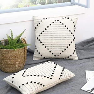 Detail of bohemian tufted cushion covers with black tassels and geometric diamond patterns