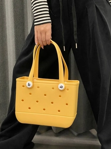 Close-up of a yellow waterproof EVA tote bag showing perforated holes and b logo detail