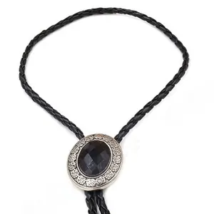Detailed view of western bolo tie with black patterned gemstone and engraved metal slide