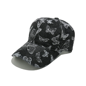 Close-up of butterfly embroidery detail on washed grey denim baseball cap
