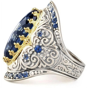 Macro di un anello in stile palazzo vintage con gemma blu ovale e intagli floreali
