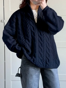 Detail of navy blue cable knit sweater with half-zip collar and relaxed casual fit