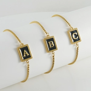 Adjustable gold plated stainless steel initial bracelet with black enamel square charms