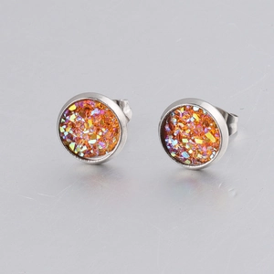 Detail of 8mm stainless steel stud earrings featuring orange glitter inlay on silver base