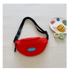 Detail of red crescent canvas chest bag for kids featuring adjustable nylon strap and zipper