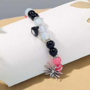 Close-up of Halloween magnetic couple bracelet featuring a silver spider charm and beads