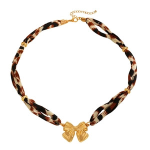 Détail du collier ruban léopard avec pendentif nœud doré et fermoir mousqueton réglable