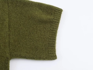 Detailed macro view showing the green knitted fabric texture and ribbed cuff design