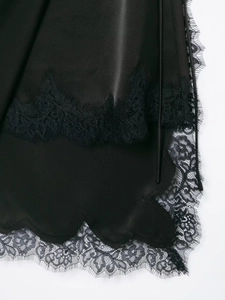 Dettaglio del tessuto in raso nero con raffinato bordo in pizzo a ciglia per donna