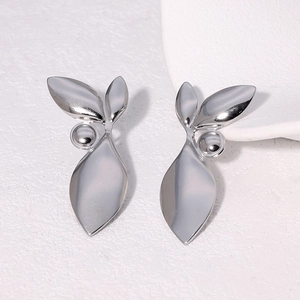 Detailed close-up of leaf and berry design earrings in polished silver finish