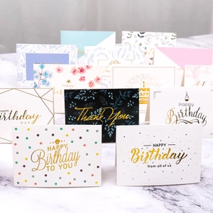 Detailed view of assorted gift cards with gold foil patterns on marble texture background