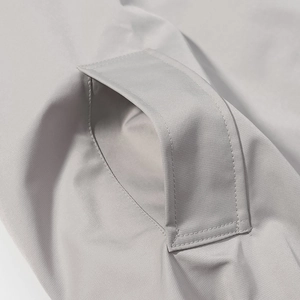 Close-up of precise stitching and pocket detail on grey high-collar trench coat