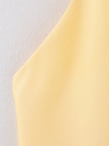 Gros plan sur la texture satinée jaune clair et le tricot fin du haut dos nu à licou