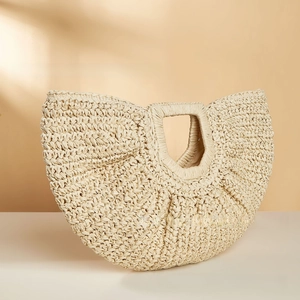 Detailed close-up showing the intricate woven texture and cutout handle of this straw beach bag