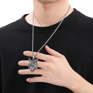 Detail of a vintage silver wolf head pendant necklace on a model with punk aesthetic