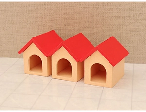 Three mini wooden dollhouse Christmas cottages with red pointed roofs and arched doors