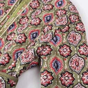 Close-up of olive green quilted jacket featuring colorful floral and geometric prints