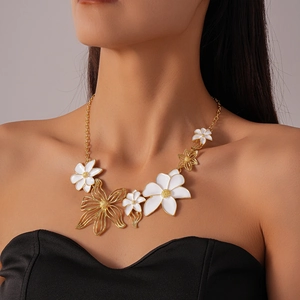 Close-up of model wearing a vintage floral necklace with white enamel and gold details
