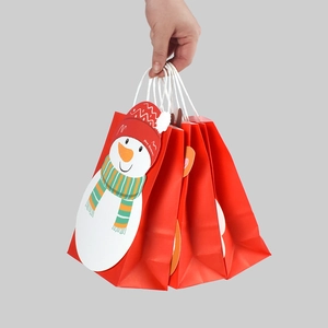 Red Christmas paper gift bag featuring a cute cartoon snowman and Merry Christmas text