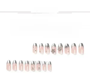 Detail of French ballet style press-on nails with silver glitter edges and star rhinestones