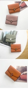 Detailed view of lychee grain leather wallets with metal clasps in orange, pink and green