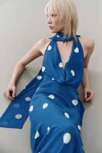 Détail d'une robe bleue à pois avec licou, décolleté en V et tissu en mousseline légère