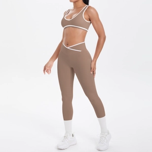 Detail eines mokkabraunen Yoga-Sets mit weißer Paspelierung und Cross-V-Taillenbund