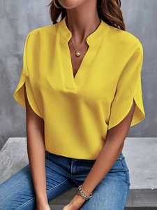 Detailed close-up of V-neckline and split cuffs on a bright yellow summer chiffon blouse