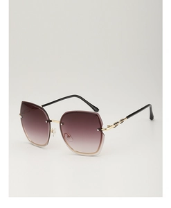 Detail of gradient lenses and golden chain link temples on rimless oversized sunglasses