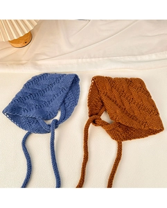 Detail of blue and brown crochet knit baby hats with textured weave and long ties