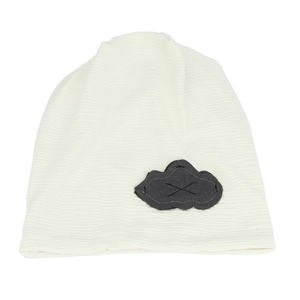 Detail of cream knit slouchy beanie featuring a grey cloud patch and ribbed texture