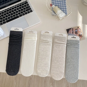 Gros plan de chaussettes côtelées en coton peigné aux tons neutres sur table de travail