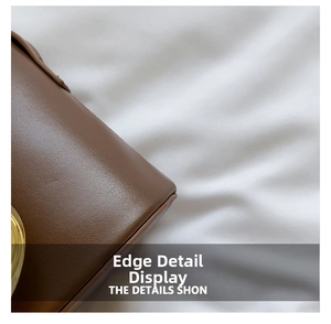Detail shot of brown leather bag showing meticulous stitching and gold metal lock hardware