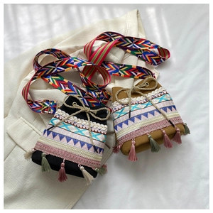 Detailed shot of ethnic bucket bags with embroidery, colorful tassels and wide straps